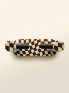 Checkerboard special-edition Roto mounted on a cream wall without a toilet paper roll.