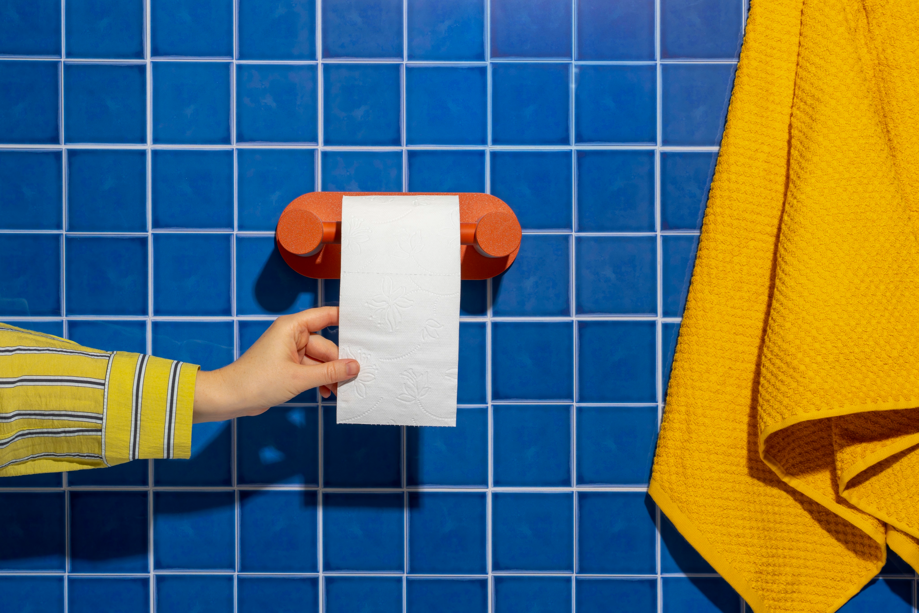 The Roto in a tiled blue bathroom with yellow towel
